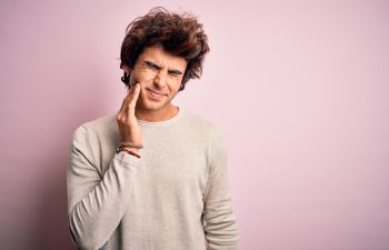 Young man suffering from dental pain.