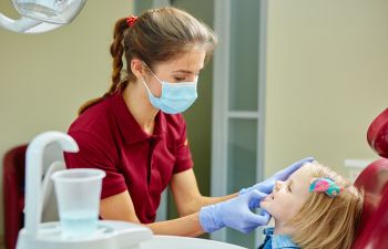 little girl during teeth exam at a pediatric dentist